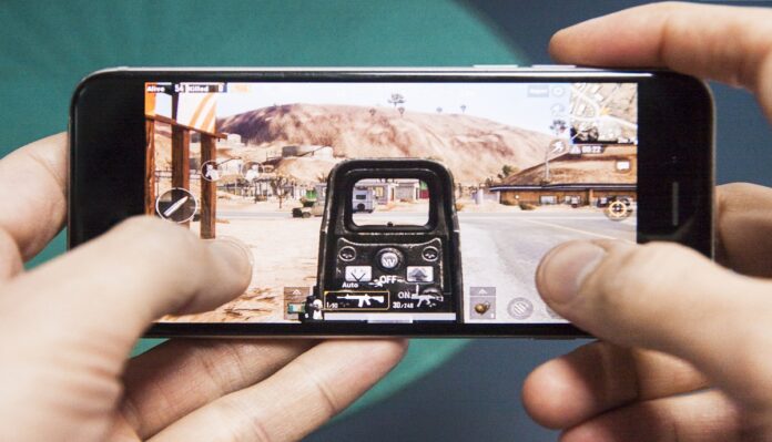 Los Angeles, California, USA - 17 December 2018: Hands holding a smartphone with PUBG FPS game