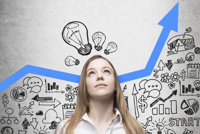 Business lady is looking for new business ideas. Blue growing arrow as a concept of successful business. Business icons are drawn on the concrete wall.