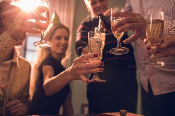 close-up-of-group-of-friends-pouring-champagne-on-a-party