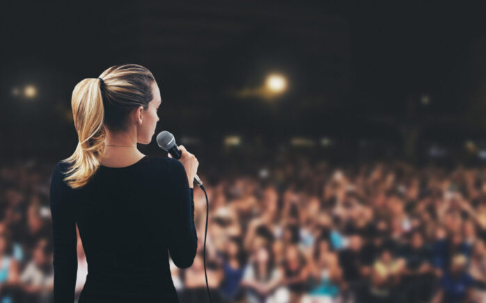 Donna con microfono su palco pubblico
