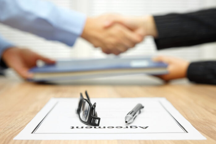 Businessman,And,Businesswoman,Are,Shaking,Hands,And,Exchanging,Folder,After