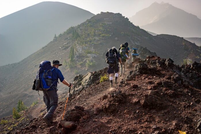 Hikers on a cliff edge overlooking a dramatic mountain range in Europe