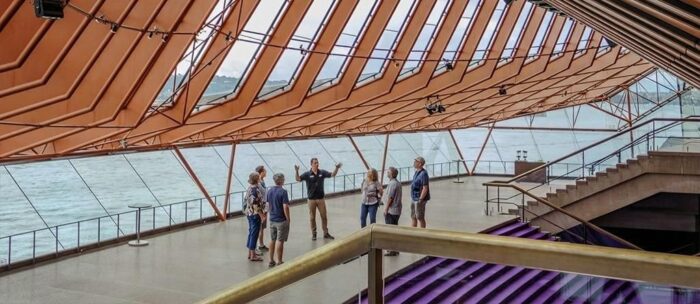 A guide explaining things to a group of people on a guided Opera House interior tour